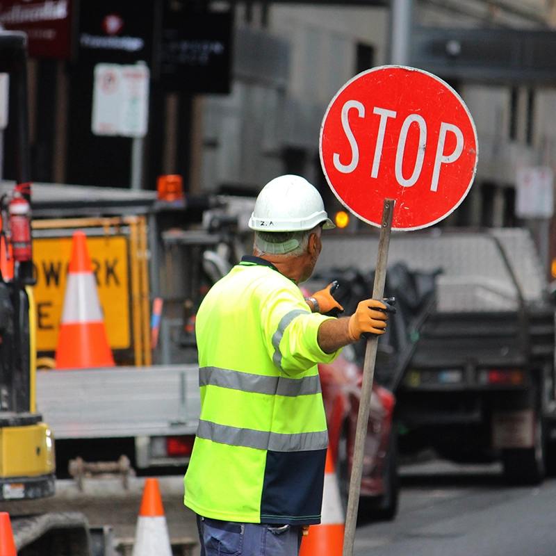 a traffic control specialist holding a stop sign